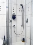  Poněkud chladnou kombinaci bílé a chromu oživují tmavě modré doplňky. Nejen v podobě koupelnové předložky či ručníku, ale i jako barevný skleněný prvek na ručce sprchy (HANSGROHE) a WC kartáč 