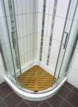  Sprchový kout značky TDA s názvem Ego Tondo v chromové úpravě hliníku. Bílá keramická vanička Kerason má rozměry 90 x 90 cm, k zvýšení komfortu při sprchování slouží teaková podložka 