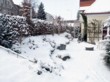  Přední partie navazující na dům je chráněna živým plotem, svah zpevňují kamenné zídky 