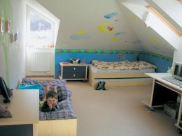 Nábytek do dětského pokoje v kombinaci světlého dřeva a tmavě modré pořídili majitelé velmi levně v prodejně Sconto. Dětský pokojík zatím sdílejí oba sourozenci společně